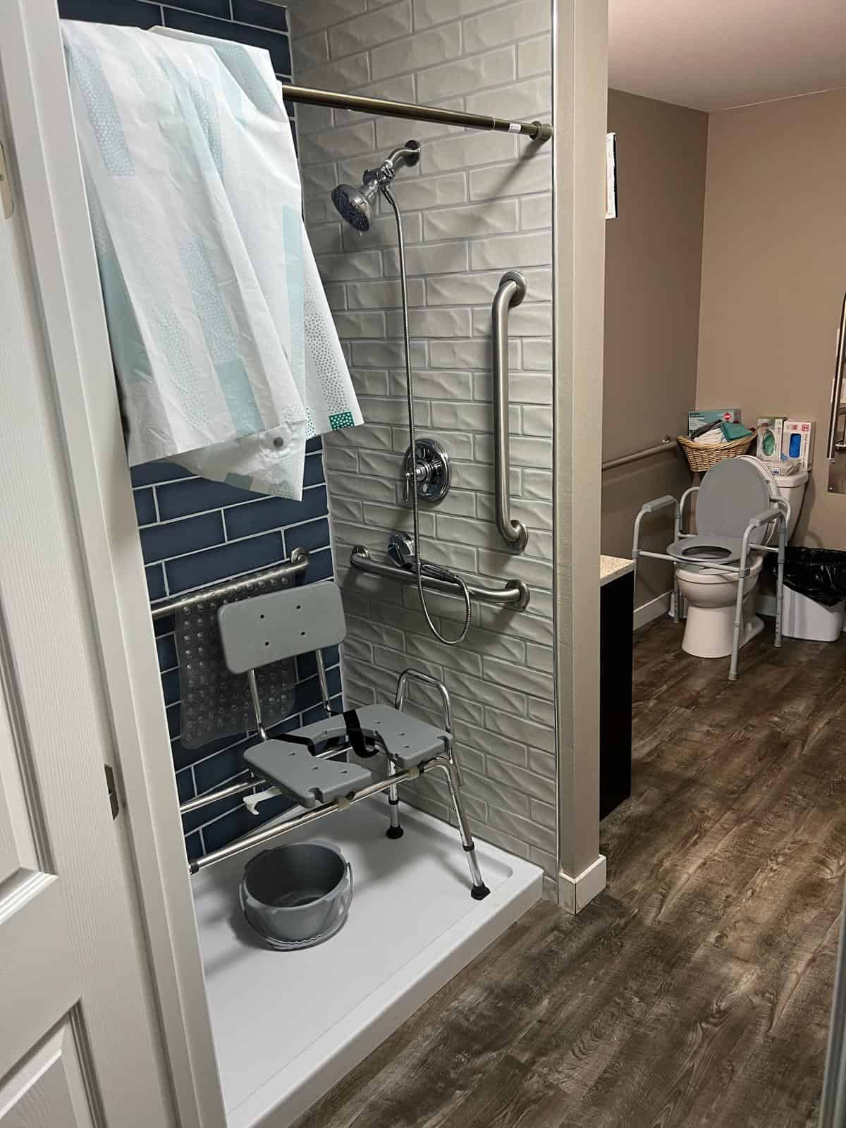 Barrier-free walk-in shower with grab bars and non-slip tiles, designed for safe independent or assisted use